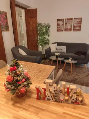 a living room with a table with a christmas tree at Apartamento 'Mini Jungle' en el corazón de Cádiz in Cádiz