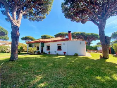 a white house with a red roof and trees at Chalet Roche a 300 metros de la playa in Roche