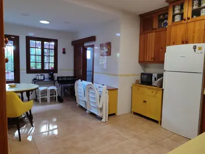a kitchen with a white refrigerator and a table at Chalet Roche a 300 metros de la playa in Roche