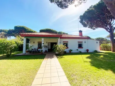 a small white house with a grass yard at Chalet Roche a 300 metros de la playa in Roche