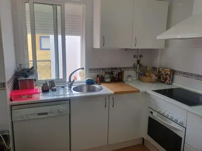 a kitchen with white cabinets and a sink and a window at Bogavante Costa Ballena in Rota