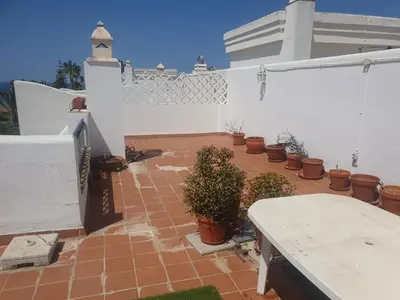 a patio with potted plants and a white fence at Bogavante Costa Ballena in Rota