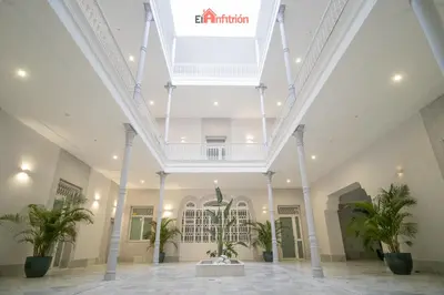 a large building with a white ceiling and potted plants at El Anfitrión - Argüeso 8 in Sanlúcar de Barrameda