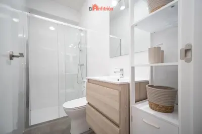a white bathroom with a toilet and a shower at El Anfitrión - Argüeso 8 in Sanlúcar de Barrameda