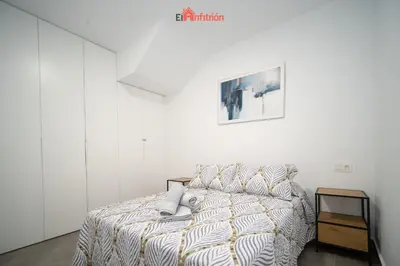 a bedroom with a bed and a picture on the wall at El Anfitrión - Argüeso 8 in Sanlúcar de Barrameda