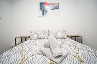 a bedroom with a bed with towels on it at El Anfitrión - Argüeso 8 in Sanlúcar de Barrameda