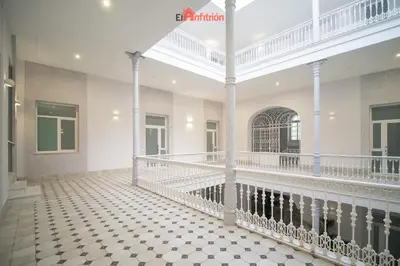 a large room with white columns and a tiled floor at El Anfitrión - Argüeso 8 in Sanlúcar de Barrameda