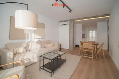 a living room with a white couch and a table at El Anfitrión - Mirador en casco antiguo con parking in Sanlúcar de Barrameda