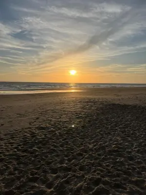 a sunset on a beach with the ocean at Costa Ballena & Eleven Lights in Chipiona