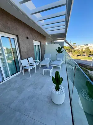 a patio with white chairs and a cactus at Costa Ballena & Eleven Lights in Chipiona
