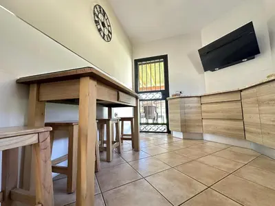 a living room with a table and a tv on the wall at Apartamentos Chiclana Chalet Carboneros in Chiclana de la Frontera
