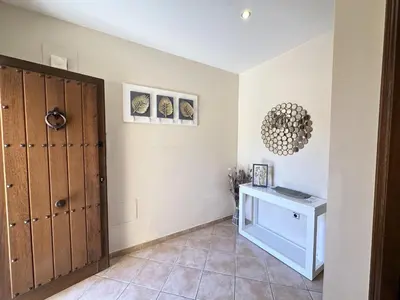 a room with a hallway with a door and a table at Apartamentos Chiclana Chalet Carboneros in Chiclana de la Frontera