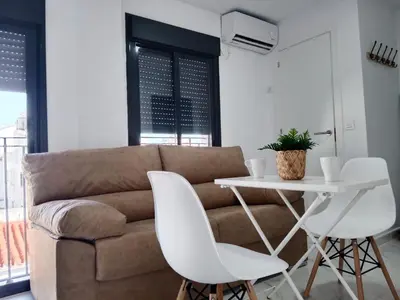 a living room with a couch and a table and chairs at Apartamento Gloria Bendita in Jerez de la Frontera
