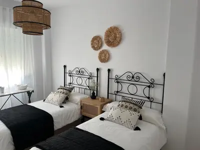 two beds in a room with white walls at Casa Gran Cinema in Sanlúcar de Barrameda