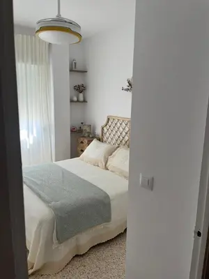 a bedroom with a bed with a blue blanket on it at Casa Gran Cinema in Sanlúcar de Barrameda