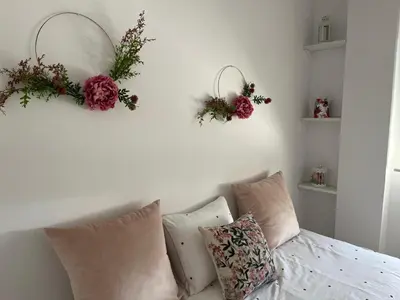 a living room with a couch and flowers on the wall at Casa Gran Cinema in Sanlúcar de Barrameda