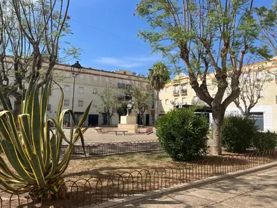 a fence with a cactus in front of a building at Casa Gran Cinema in Sanlúcar de Barrameda