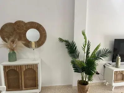 a living room with a mirror and a plant at Casa Gran Cinema in Sanlúcar de Barrameda