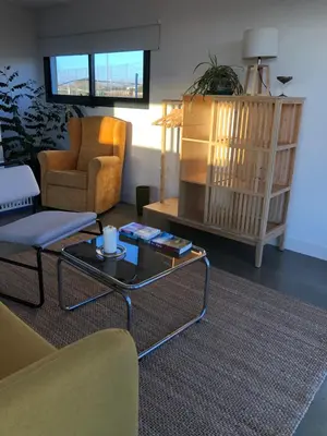a living room with a chair and a coffee table at Casa Isabelina Stay near Doñana & the Coast in Sanlúcar de Barrameda