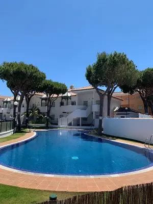 a large swimming pool in a yard with trees at Apartamento HS Costa Castillo in Poblado de Sancti Petri