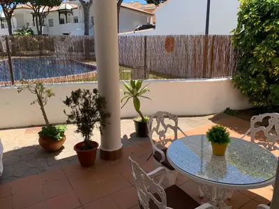 a patio with a table and chairs and a pool at Apartamento HS Costa Castillo in Poblado de Sancti Petri