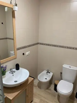 a bathroom with a sink and a toilet and a mirror at Apartamento HS Costa Castillo in Poblado de Sancti Petri