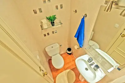 a bathroom with a white toilet and a sink at Beachfront Duplex 1ª línea & Terraces Oceanfront in El Puerto de Santa María