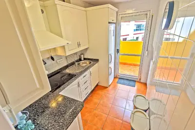 a kitchen with white cabinets and a tile floor at Beachfront Duplex 1ª línea & Terraces Oceanfront in El Puerto de Santa María