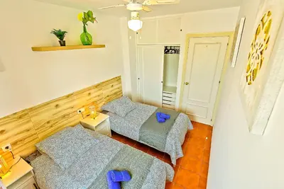 two beds in a small room with blue pillows at Beachfront Duplex 1ª línea & Terraces Oceanfront in El Puerto de Santa María