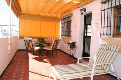 a balcony with a table and chairs in a room at Apartamento Caracola in Chipiona