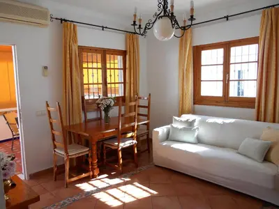 a living room with a white couch and a table at Apartamento Caracola in Chipiona