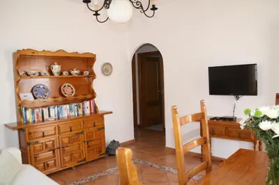 a living room with a television and a wooden dresser at Apartamento Caracola in Chipiona