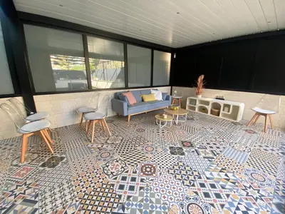 a patio with a couch and chairs on a tiled floor at El Paraíso de Fuentebravía - Primera Línea de Playa in El Puerto de Santa María