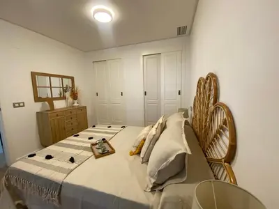 a bedroom with a large bed with a wooden headboard at El Paraíso de Fuentebravía - Primera Línea de Playa in El Puerto de Santa María