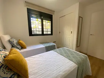 two beds in a room with a window at El Paraíso de Fuentebravía - Primera Línea de Playa in El Puerto de Santa María
