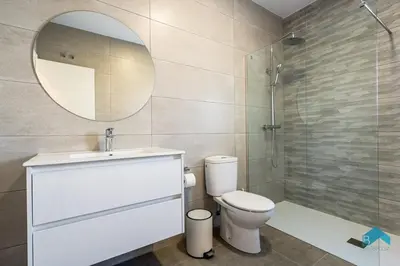 a bathroom with a toilet and a sink and a mirror at Villa Granizo C in Chiclana de la Frontera