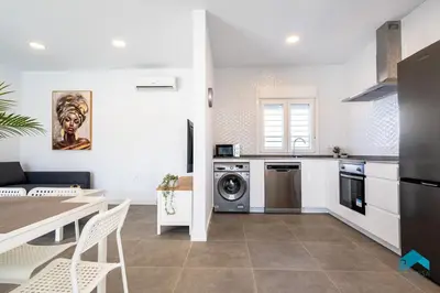 a kitchen with a table and a dining room at Villa Granizo C in Chiclana de la Frontera