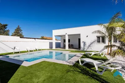a villa with a swimming pool and lawn at Villa Granizo C in Chiclana de la Frontera