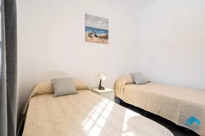 two beds sitting next to each other in a room at Villa Granizo C in Chiclana de la Frontera