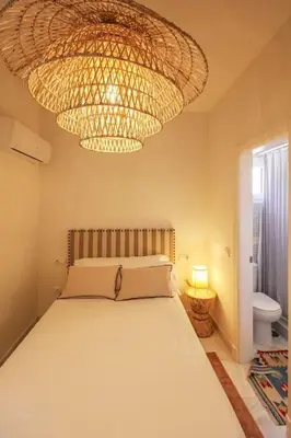 a bedroom with a bed and a large chandelier at Casa de lujo en Las Redes in El Puerto de Santa María