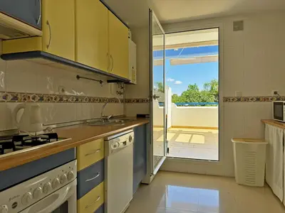 a kitchen with a sink and a door to a patio at Apartamento Playa Ballena - Ole Solutions in Costa Ballena