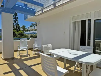 a white dining table and chairs on a patio at Apartamento Playa Ballena - Ole Solutions in Costa Ballena