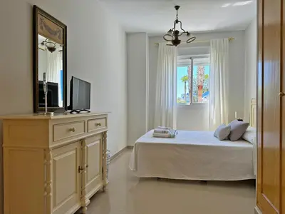 a bedroom with a bed and a dresser with a television at Apartamento Playa Ballena - Ole Solutions in Costa Ballena