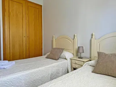 a bedroom with two beds and a night stand with a lamp at Apartamento Playa Ballena - Ole Solutions in Costa Ballena