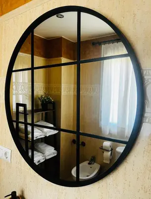 a mirror on the wall of a bathroom with a sink at Casa Familiar- Residencial Solmar in Sanlúcar de Barrameda