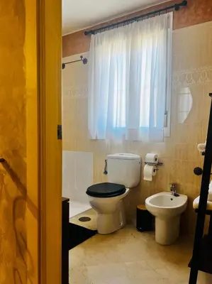 a bathroom with a toilet and a sink at Casa Familiar- Residencial Solmar in Sanlúcar de Barrameda