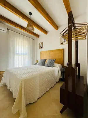 a bedroom with a large white bed in a room at Casa Familiar- Residencial Solmar in Sanlúcar de Barrameda
