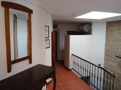 a hallway with a staircase with a black table and a window at Apartamentos Jasmund - Bungalow 117 in San Fernando