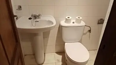 a white bathroom with a toilet and a sink at Apartamentos Jasmund - Bungalow 117 in San Fernando