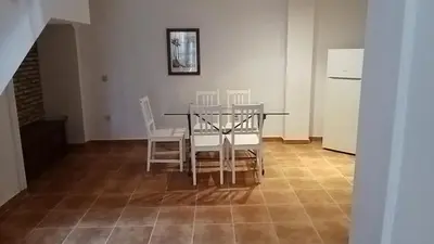 a dining room with a table and chairs and a refrigerator at Apartamentos Jasmund - Bungalow 117 in San Fernando